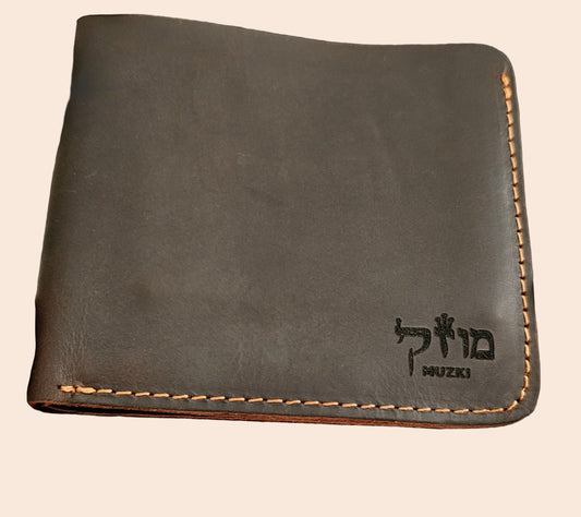 Brown leather wallet held in a hand with a blurred background